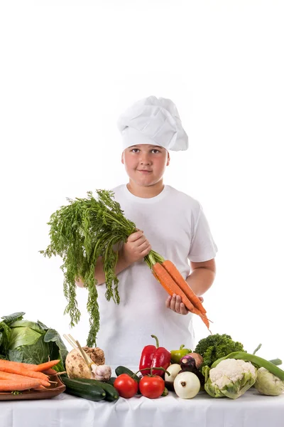 Un niño pequeño como cocinero haciendo ensalada, cocinando con verduras — Foto de Stock