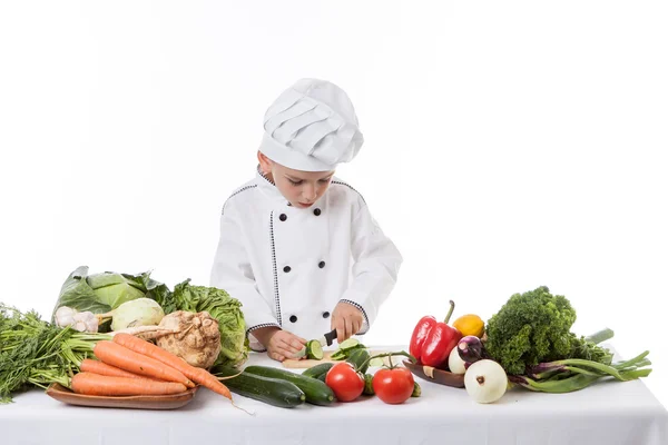 Een kleine jongen als chef kok maken salade, koken met groente — Stockfoto