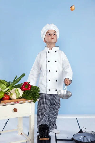 Een kleine jongen als chef kok maken salade, koken met groente — Stockfoto