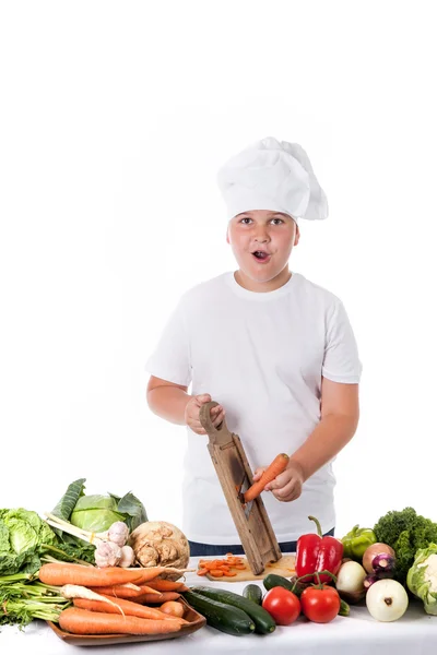 Un niño pequeño como cocinero haciendo ensalada, cocinando con verduras —  Fotos de Stock