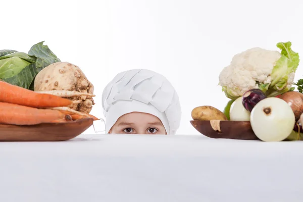 Een kleine jongen als chef kok maken salade, koken met groente — Stockfoto