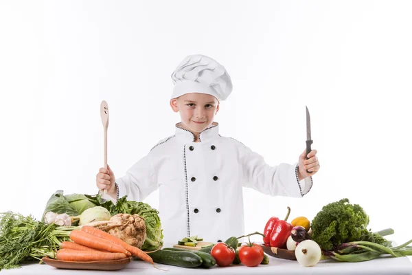 Seorang anak kecil sebagai koki memasak salad, memasak dengan sayuran — Stok Foto