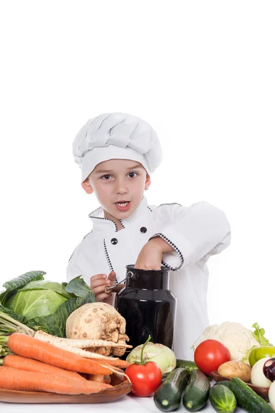 Один маленький мальчик как повар готовит салат, готовит с овощами — стоковое фото