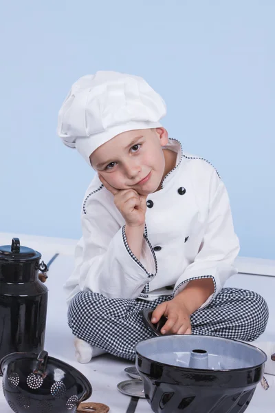 Een kleine jongen als chef kok maken salade, koken met groente — Stockfoto