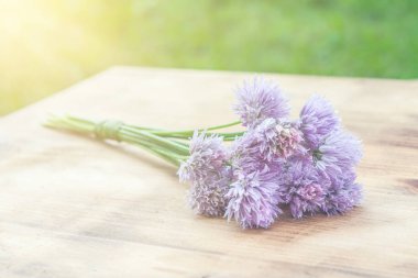 Çiçek chives bir snop bir doğal ahşap kesme tahtası üzerinde bağlı
