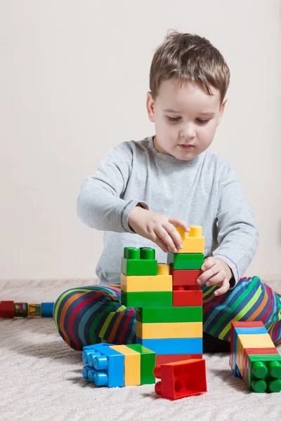 Spelen van kleine jongen met gekleurde blokjes — Stockfoto