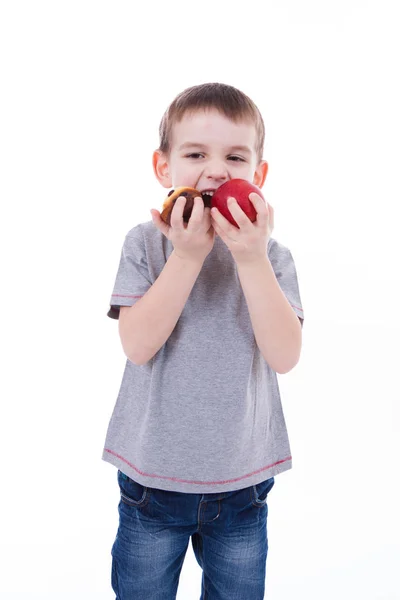 Niño pequeño con comida aislada sobre fondo blanco - manzana o magdalena — Foto de Stock