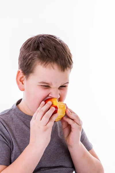 Liten pojke med mat isolerad på vit bakgrund - apple eller en muffin — Stockfoto