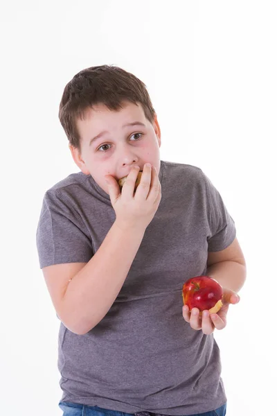 Niño pequeño con comida aislada sobre fondo blanco - manzana o magdalena —  Fotos de Stock