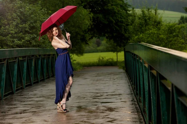 Young attractive woman after rain in nature