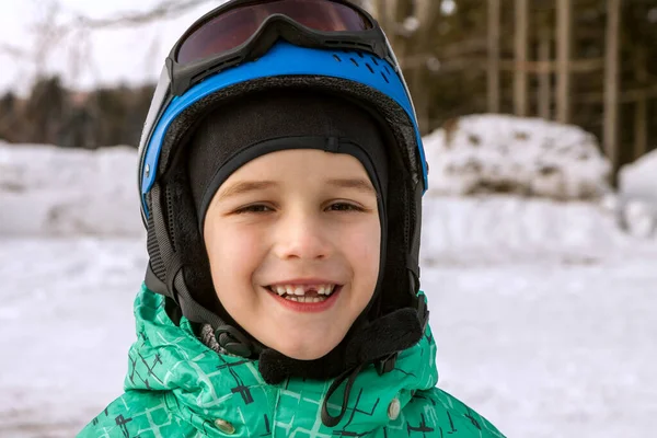 Little boy on mountains in ski helmet with fallen first tooth — Stock Photo, Image