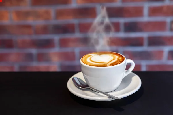 Een kopje koffie op een met hart, Valentijnsdag, rode muur — Stockfoto