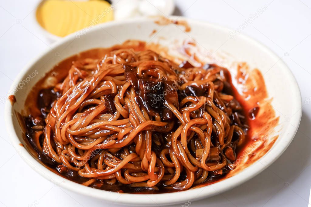 Korean Black bean noodle - jajangmyeon noodle with black sauce and vegetable in white bowl