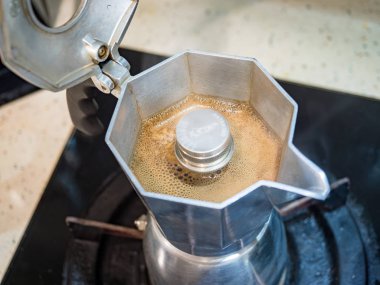 Moka kahve makinesini yakın plan kullanarak koyu moka kahve yapmak.