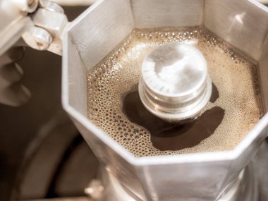 Moka kahve makinesini yakın plan kullanarak koyu moka kahve yapmak.