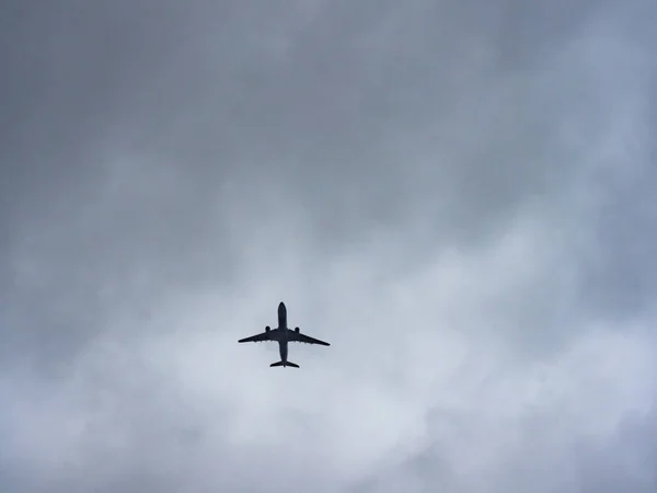曇った空に対する旅客機のシルエット — ストック写真