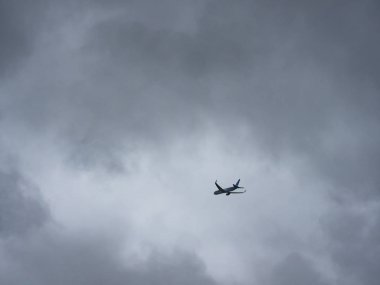 Bulutlu gökyüzüne karşı jet silueti