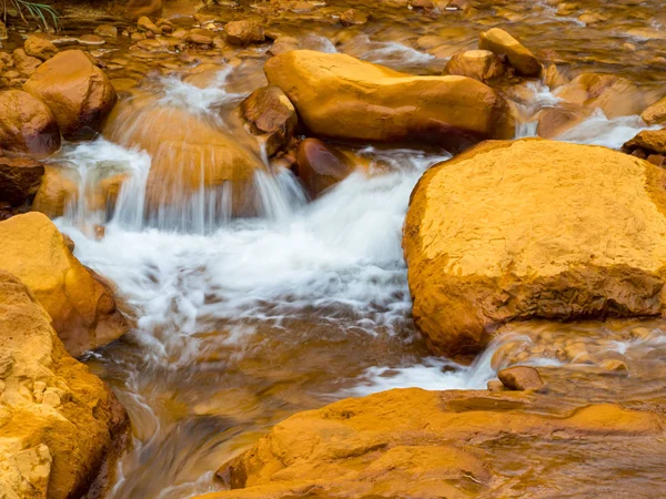 Smooth flowing water falling over rocks