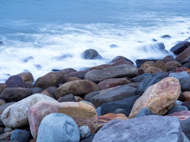 Güzel ipeksi su dalgaları ve deniz kıyısındaki kayalar