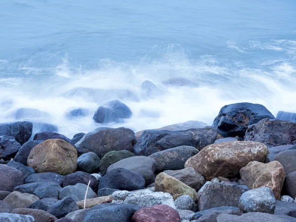 beautiful silky smooth water waves and rocks on the sea shore