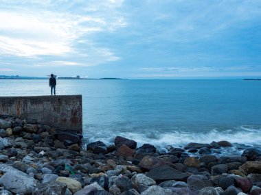 Güzel ipeksi su dalgaları ve deniz kıyısındaki kayalar