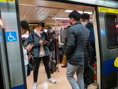Taipei, Tayvan 'da toplu taşıma sisteminde maske takan yolcular.