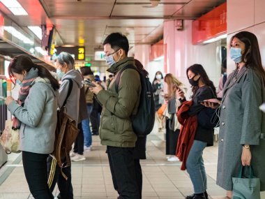 Taipei, Tayvan 'da toplu taşıma sisteminde maske takan yolcular.