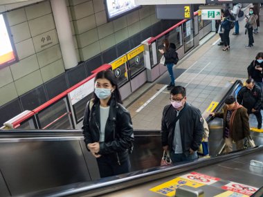 Taipei, Tayvan 'da toplu taşıma sisteminde maske takan yolcular.