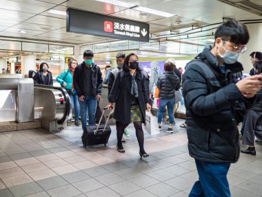 Taipei, Tayvan 'da toplu taşıma sisteminde yüz maskesi takan yolcular.
