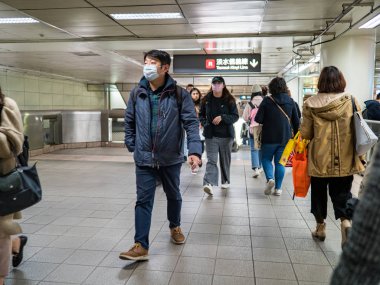 Taipei, Tayvan 'da toplu taşıma sisteminde yüz maskesi takan yolcular.