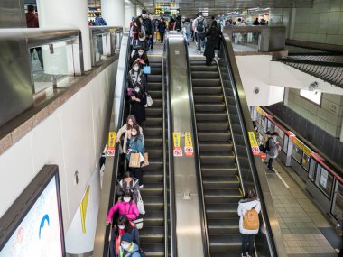 Taipei, Tayvan 'da toplu taşıma sisteminde yüz maskesi takan yolcular.
