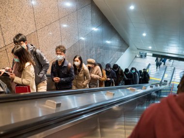 Taipei, Tayvan 'da toplu taşıma sisteminde yüz maskesi takan yolcular.