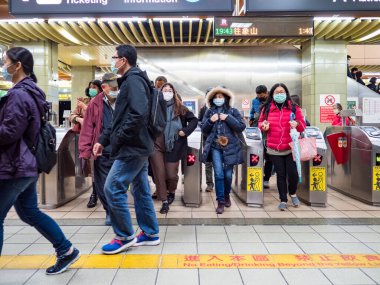 Taipei, Tayvan 'da toplu taşıma sisteminde yüz maskesi takan yolcular.