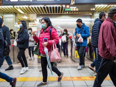 Taipei, Tayvan 'da toplu taşıma sisteminde yüz maskesi takan yolcular.