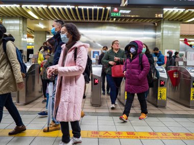 Taipei, Tayvan 'da toplu taşıma sisteminde yüz maskesi takan yolcular.