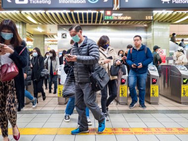 Taipei, Tayvan 'da toplu taşıma sisteminde yüz maskesi takan yolcular.