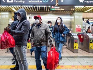 Taipei, Tayvan 'da toplu taşıma sisteminde yüz maskesi takan yolcular.