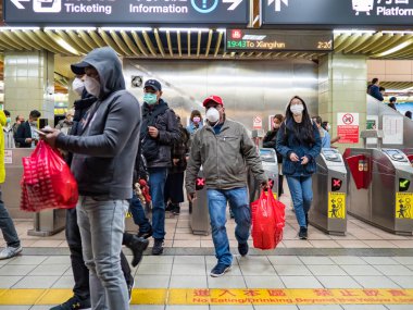 Taipei, Tayvan 'da toplu taşıma sisteminde yüz maskesi takan yolcular.
