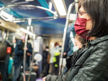 Taipei, Tayvan 'da toplu taşıma sisteminde yüz maskesi takan yolcular.