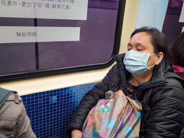 Taipei, Tayvan 'da toplu taşıma sisteminde yüz maskesi takan yolcular.