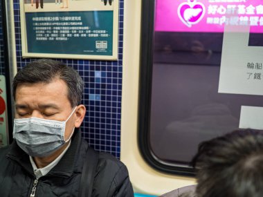 Taipei, Tayvan 'da toplu taşıma sisteminde yüz maskesi takan yolcular.