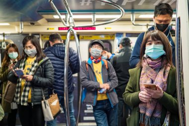 Taipei, Tayvan 'da toplu taşıma sisteminde yüz maskesi takan yolcular.