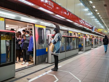 Taipei, Tayvan 'da toplu taşıma sisteminde yüz maskesi takan yolcular.