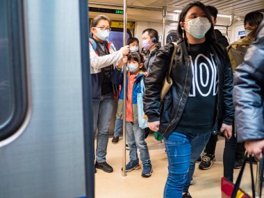 Taipei, Tayvan 'da toplu taşıma sisteminde yüz maskesi takan yolcular.