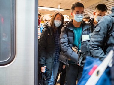Taipei, Tayvan 'da toplu taşıma sisteminde yüz maskesi takan yolcular.