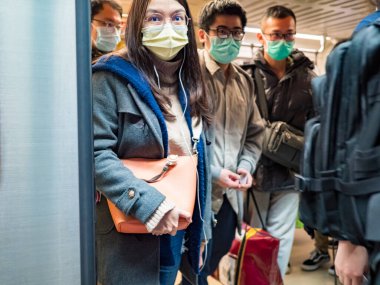 Taipei, Tayvan 'da toplu taşıma sisteminde yüz maskesi takan yolcular.