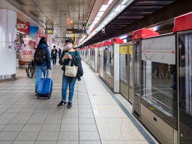 Taipei, Tayvan 'da toplu taşıma sisteminde yüz maskesi takan yolcular.