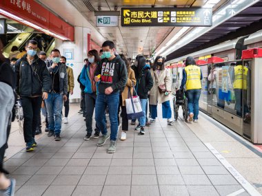 Taipei, Tayvan 'da toplu taşıma sisteminde yüz maskesi takan yolcular.
