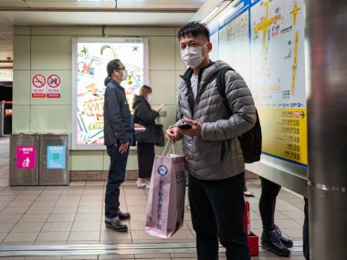 Taipei, Tayvan 'da toplu taşıma sisteminde yüz maskesi takan yolcular.
