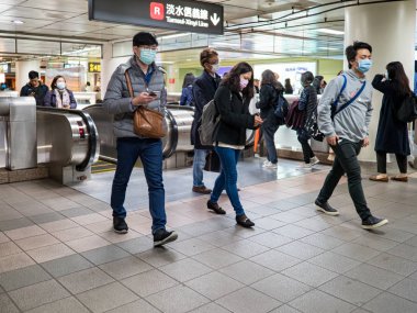 Taipei, Tayvan 'da toplu taşıma sisteminde yüz maskesi takan yolcular.